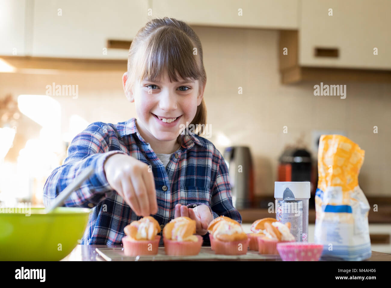 Portrait von Mädchen in der Küche hausgemachte Muffins verzieren Stockfoto