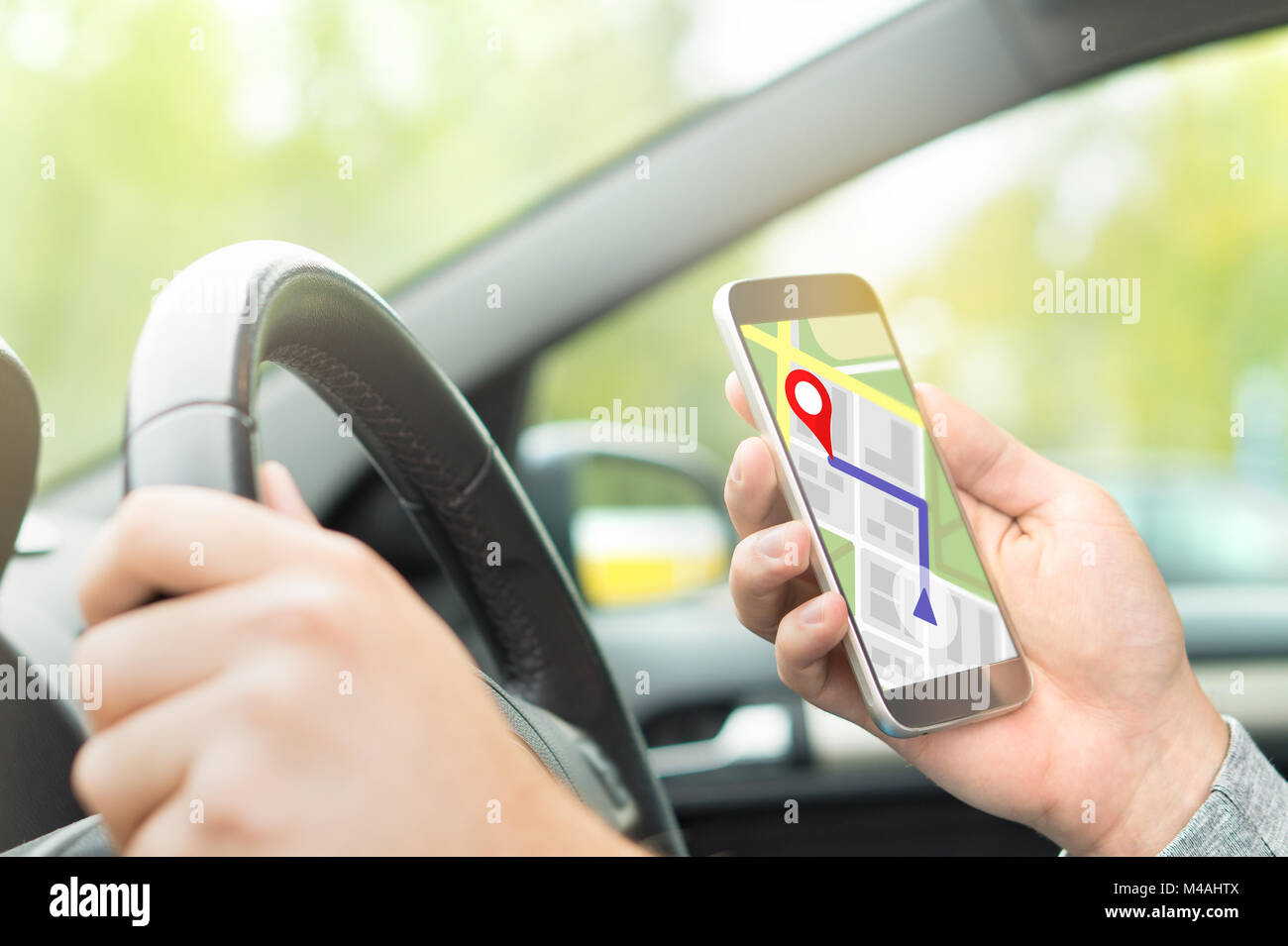 Man Autofahren und mithilfe von Karte und GPS-Anwendung auf mit Smart Phone. Navigation mit mobilen App. Innenansicht im Auto. Stockfoto