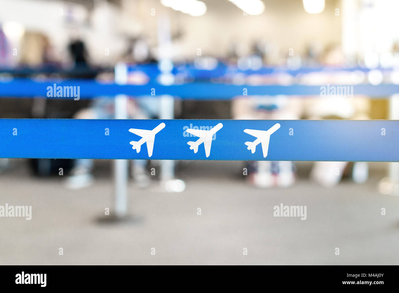 Flughafen Wartebereich, in der Lobby oder in der Lounge. Flugzeugsymbol in der Warteschlange Barriere. Passagiere, die im Hintergrund sitzen. Reisen und Ferien. Stockfoto