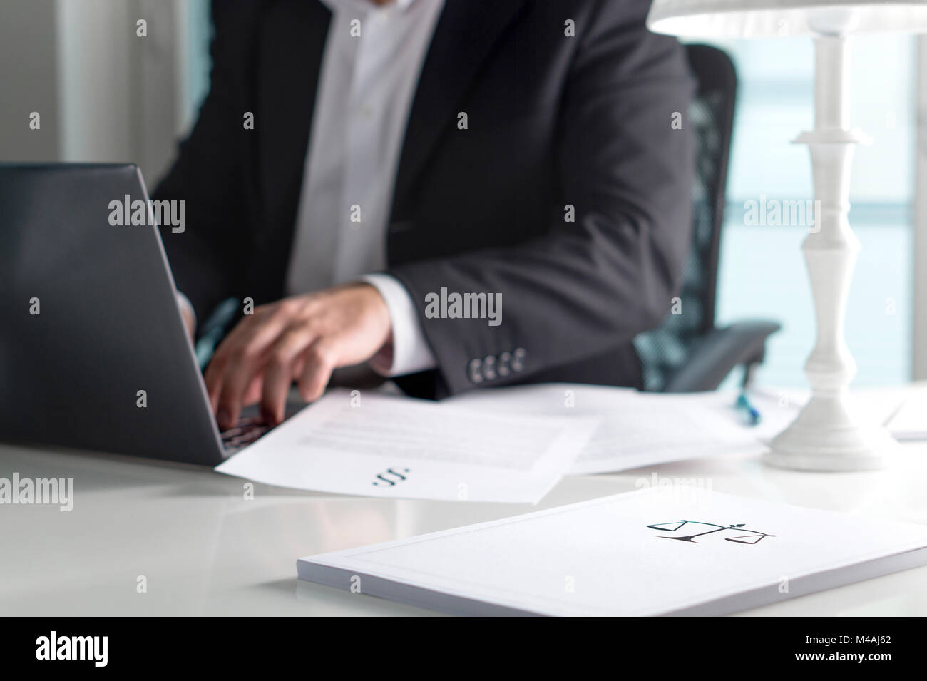 Skala und Gerechtigkeit Zeichen auf Stapel Papier. Rechtsanwalt im Büro. Rechtsanwalt schreiben ein juristisches Dokument mit Laptop. Stockfoto