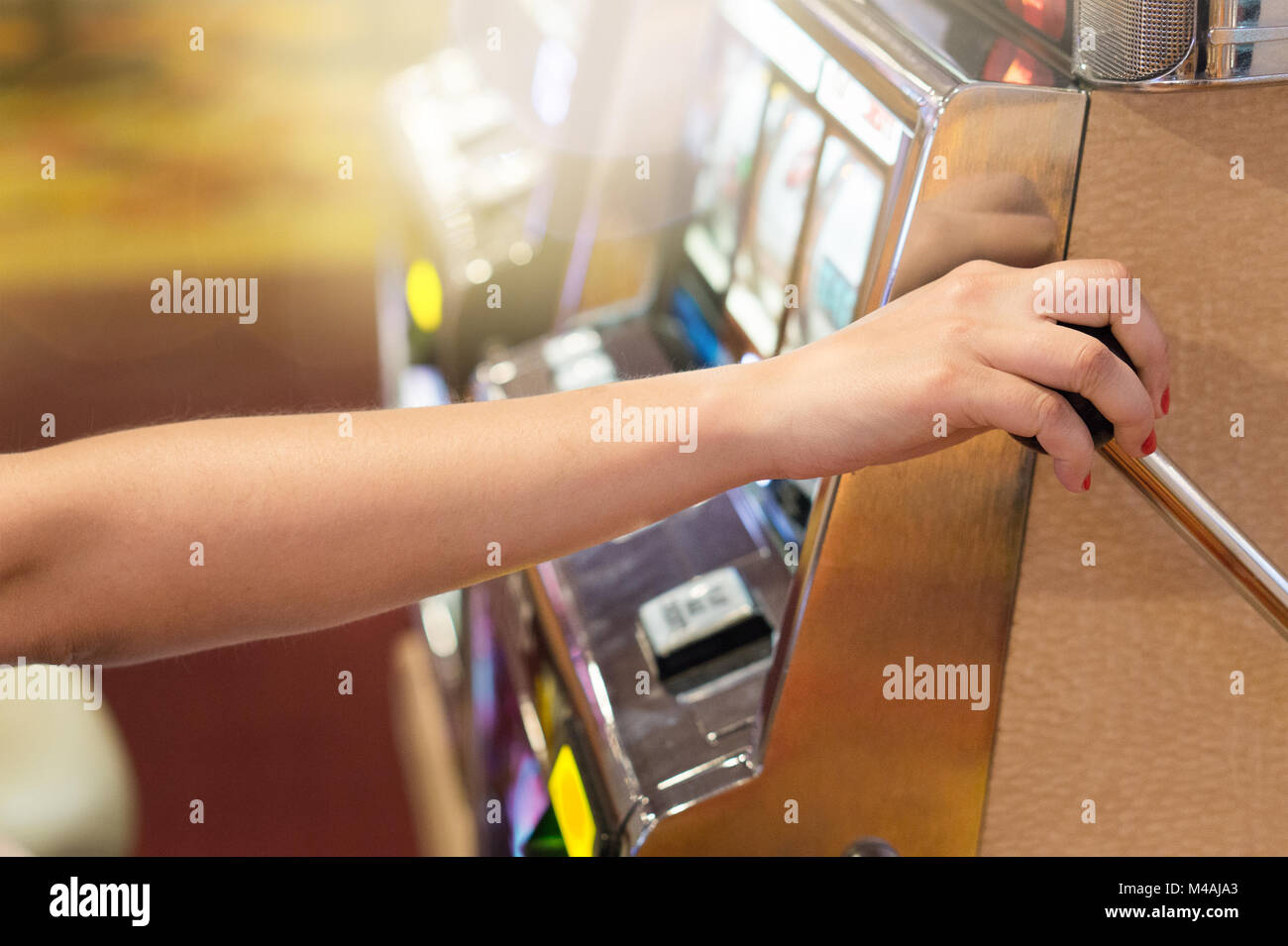 Frau ziehen der Slot Maschine in einem Casino. Glücksspiel, Glück, Risiko und gewinnen Jackpot Konzept. Spieler spielen in Las Vegas. Stockfoto