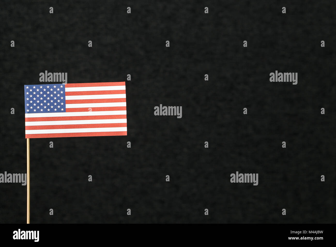 Die Flagge der Vereinigten Staaten von Amerika (USA) aus Papier auf Holz stick gegen den dunklen Hintergrund mit negativen kopieren Platz für Text. Stockfoto