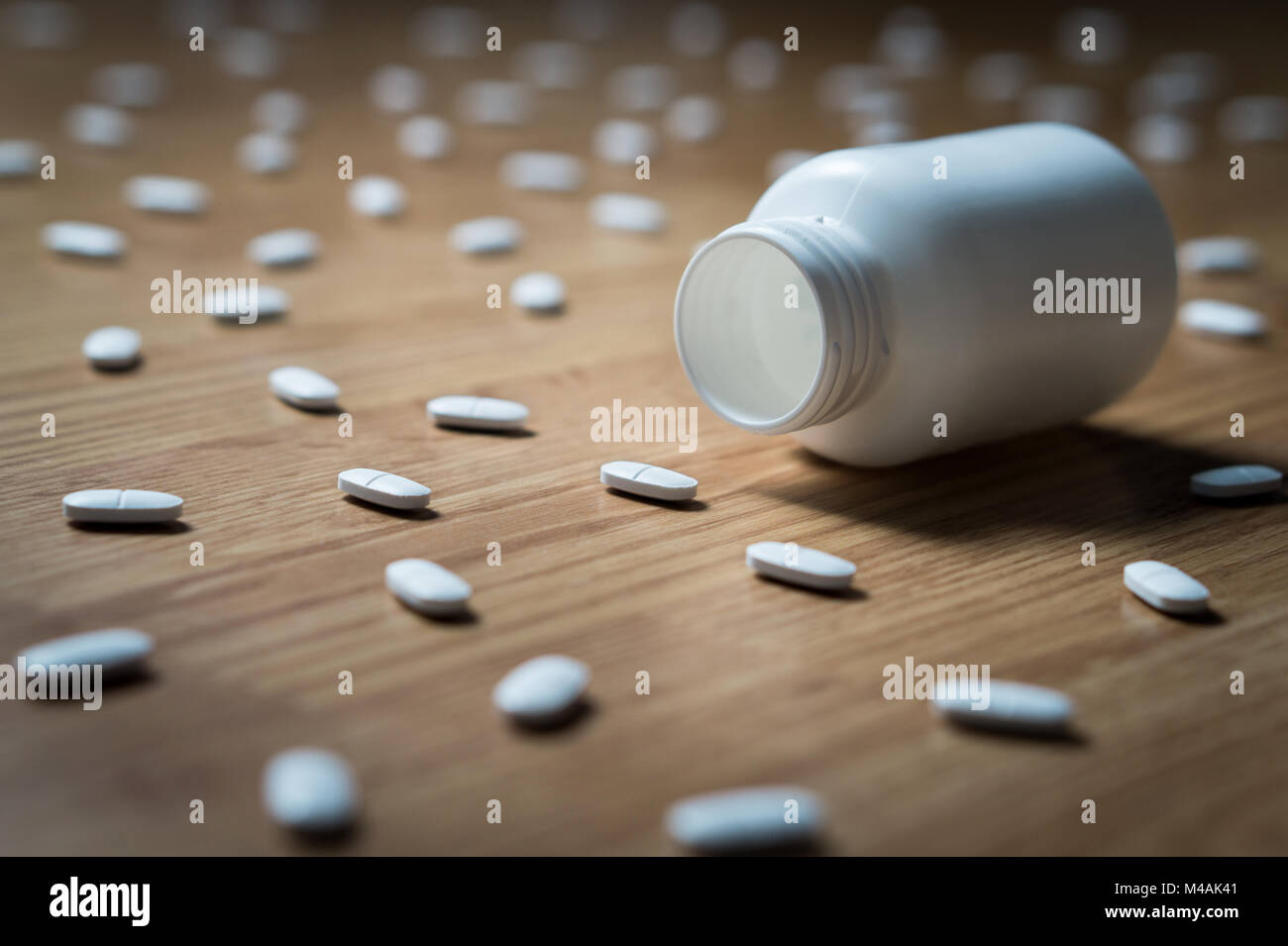 Drogensucht, medizinische Missbrauch und Drogen Haken und Abhängigkeit Konzept. Leere tablet Flasche durch viele Pillen auf dem Boden umgeben. Überdosierung Stockfoto