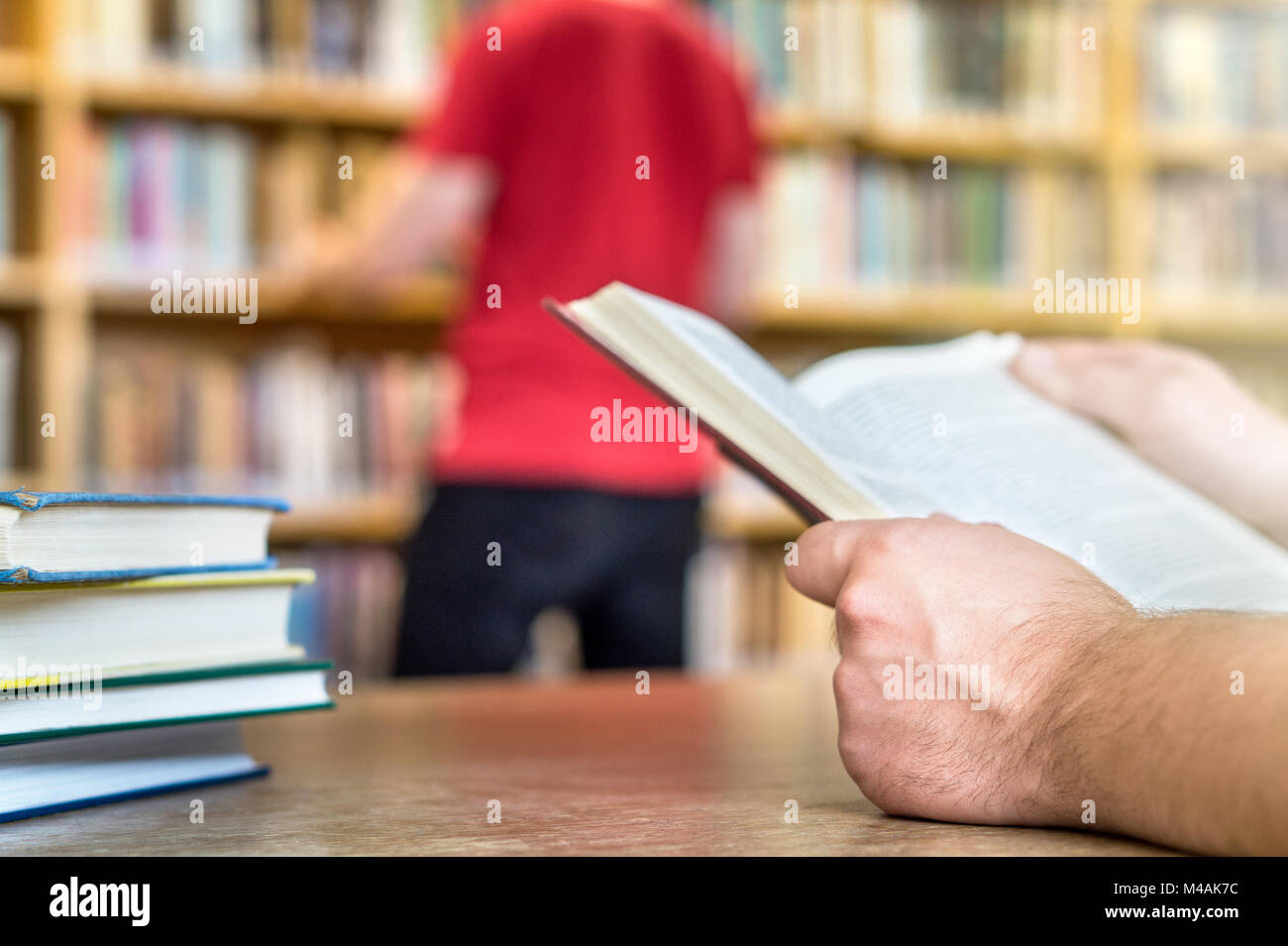 Menschen, die in öffentlichen oder Schule Bibliothek in der Hochschule oder Universität. Lesen und suchen. Bildung, Studium und Literatur Service Konzept. Stockfoto