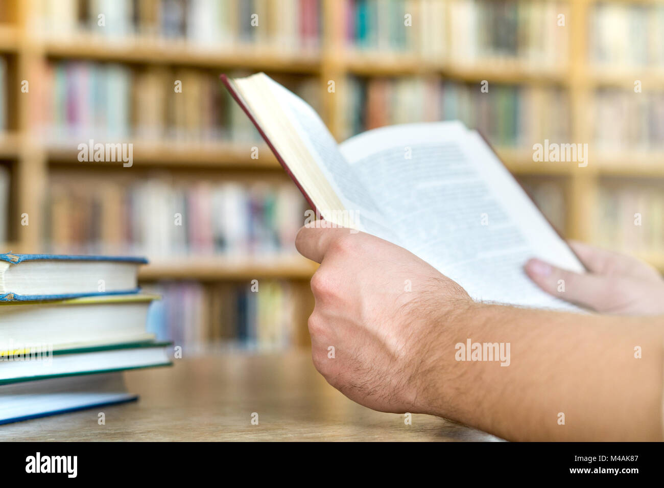 Mann oder ein Student ein Buch lesen oder in der Schule in der öffentlichen Bibliothek in der Hochschule oder Universität. Bildung, Studium und Literatur Service Konzept. Stockfoto