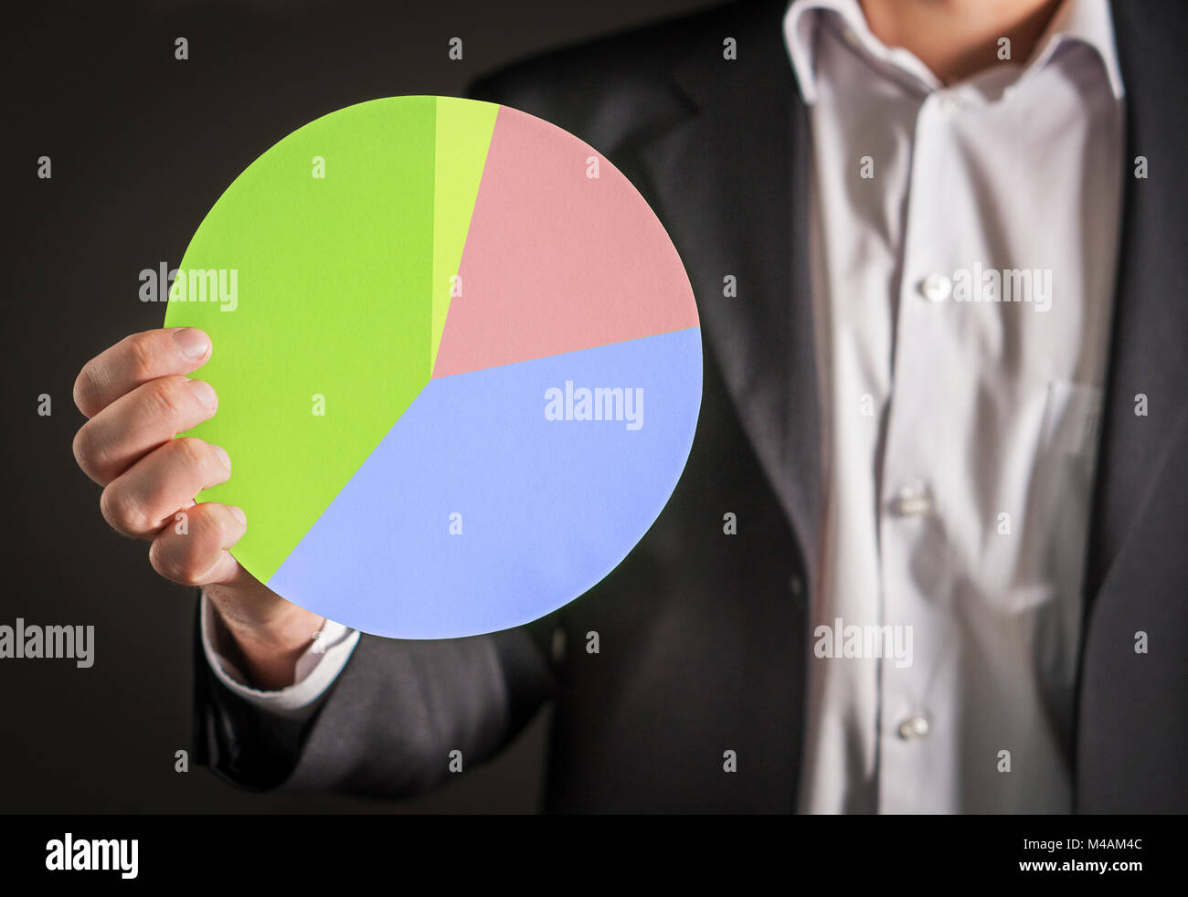 Business Mann hält ein Kreisdiagramm aus Karton Papier. Visuelle Demonstration der Finanzen Statistiken und die Markt- und Absatzsituation. Stockfoto