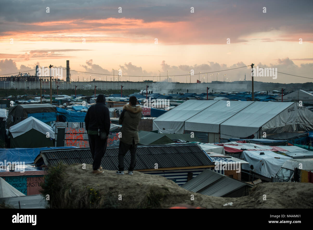 Sonnenuntergang über den Dschungel von Calais. Auf dem Hintergrund der Zaun entlang der Autobahn in Großbritannien von Calais entfernt. Stockfoto