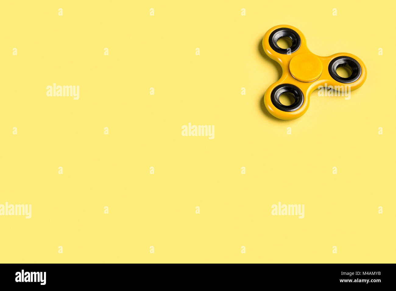 Gelbe zappeln Spinner Hintergrund Vorlage mit kopieren. Beliebte Kinder Stress und Angst relief Spielzeug in der rechten oberen Ecke. Stockfoto