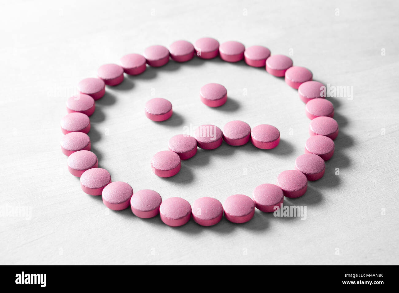 Klinische Depression, psychische Erkrankungen und Störungen oder schlechter Gesundheit Services Konzept. Traurige Smiley von Pillen, die Medizin und die Tabletten auf hölzernen Tisch Stockfoto