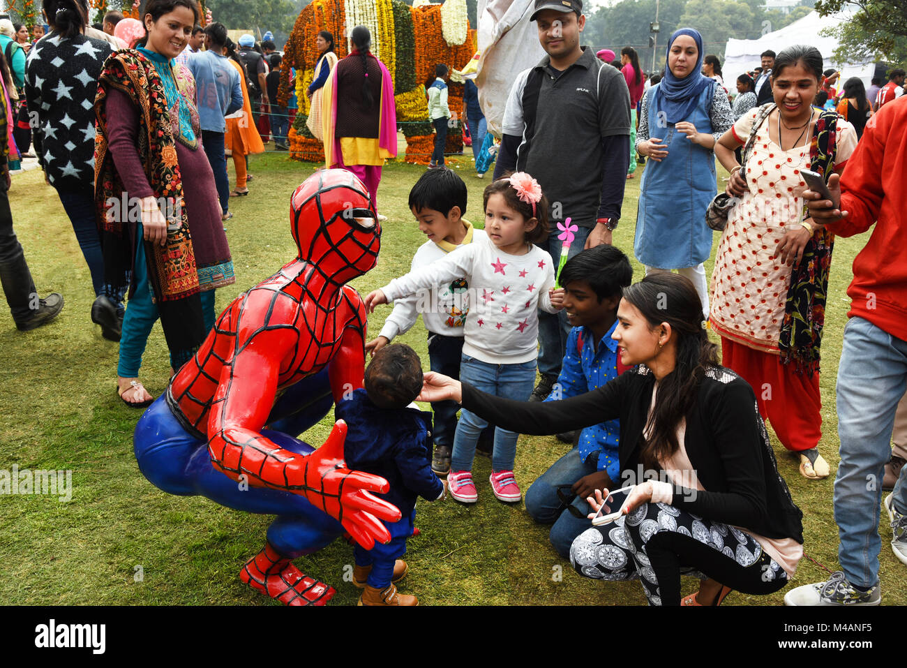 Kinder spielen mit einer Statue von Spiderman. Stockfoto