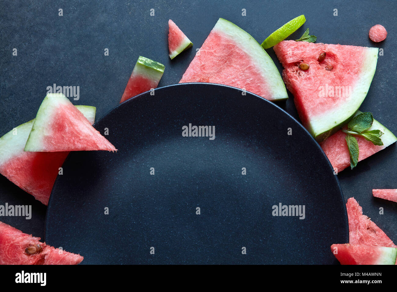Scheiben Wassermelone platziert in der Nähe der Platte schwarz Stockfoto