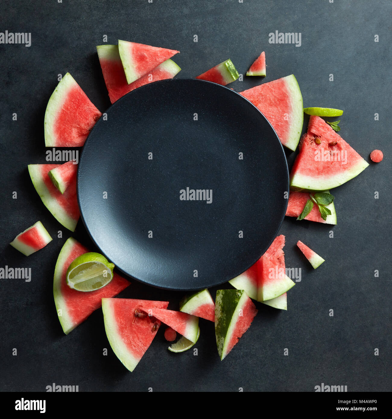 Scheiben der Wassermelone in einem Kreis auf schwarzem Teller platziert Stockfoto