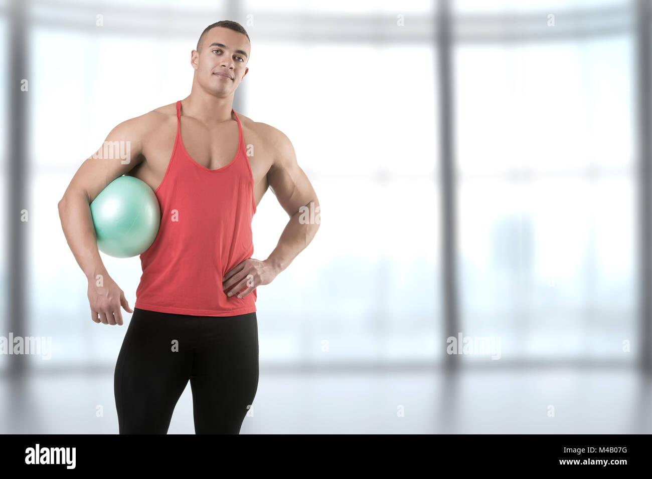 Passen Mann stand mit einem Pilates Ball Stockfoto