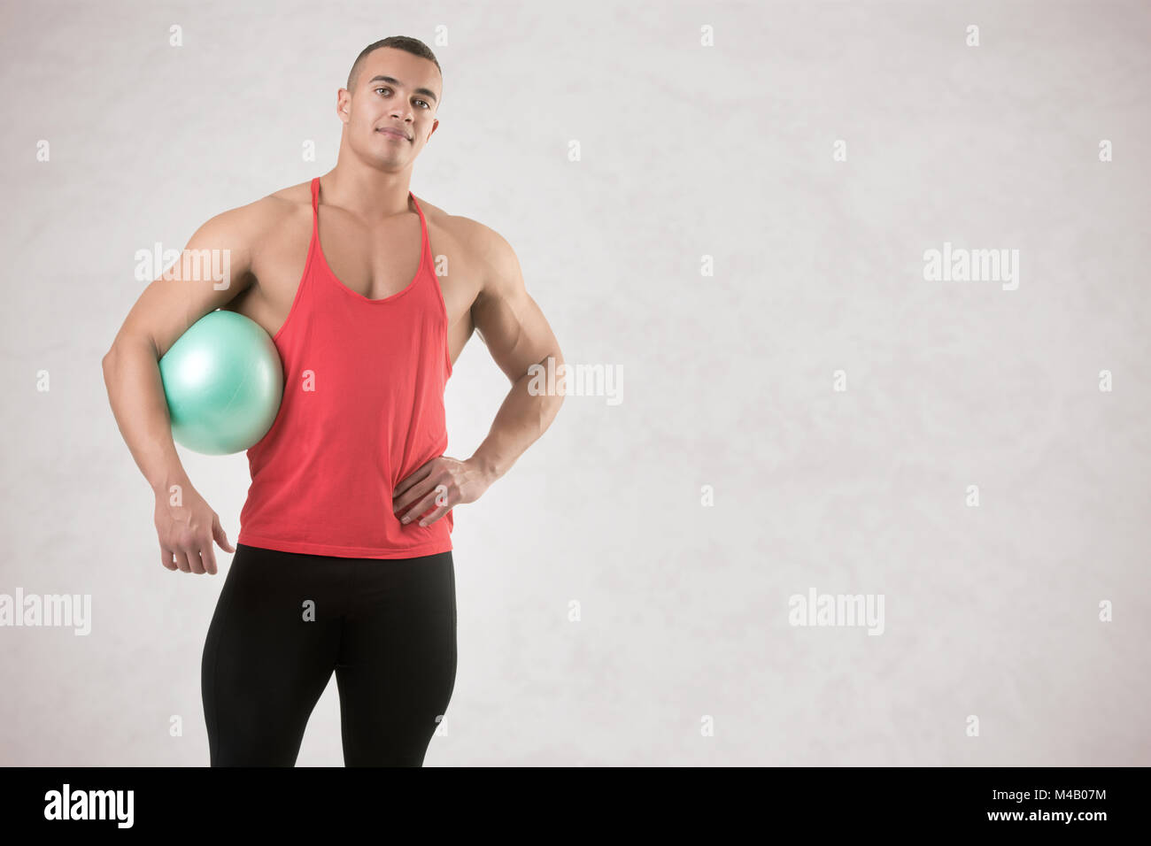 Passen Mann stand mit einem Pilates Ball Stockfoto