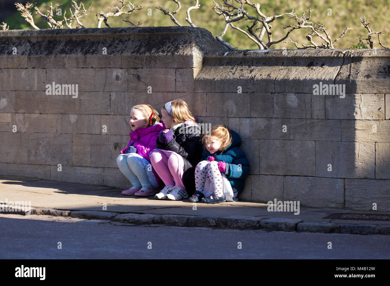 Drei junge Mädchen im Alter von 3, 5, 7 Jahre warten in der Kälte, während ihr Vater Fotos nimmt für ein Bild bestand Bibliothek wie Alamy. Schloss Windsor, Großbritannien Stockfoto