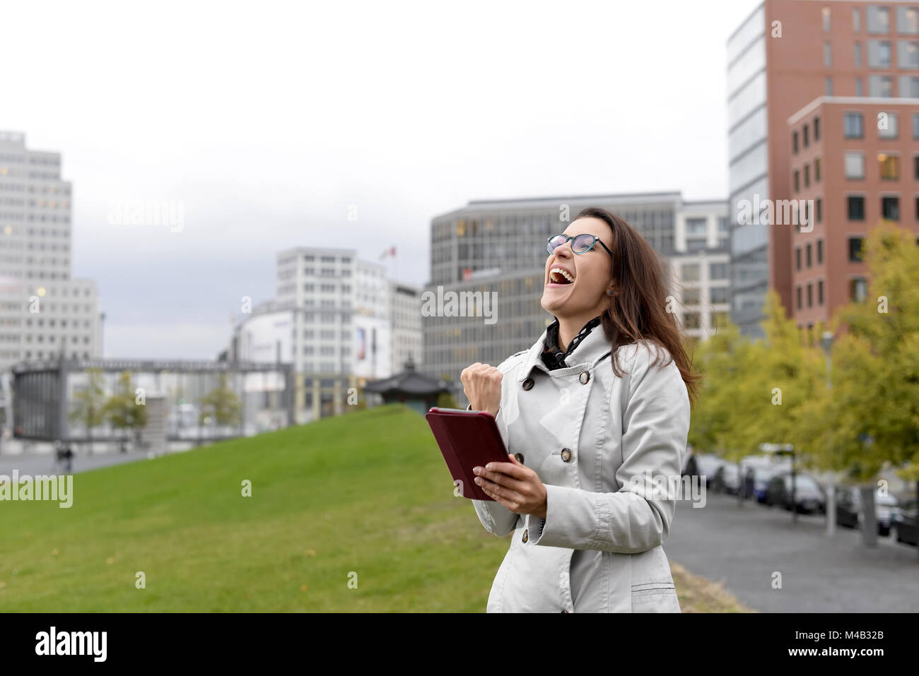 Jubelnde Geschäftsfrau mit digitalen Tablet in der Stadt Stockfoto