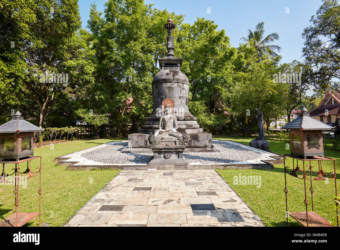 Großer Stein Stupa und sitzender Buddha Bild in den Garten von Mendut buddhistischen Kloster. Magelang Regency, Java, Indonesien. Stockfoto