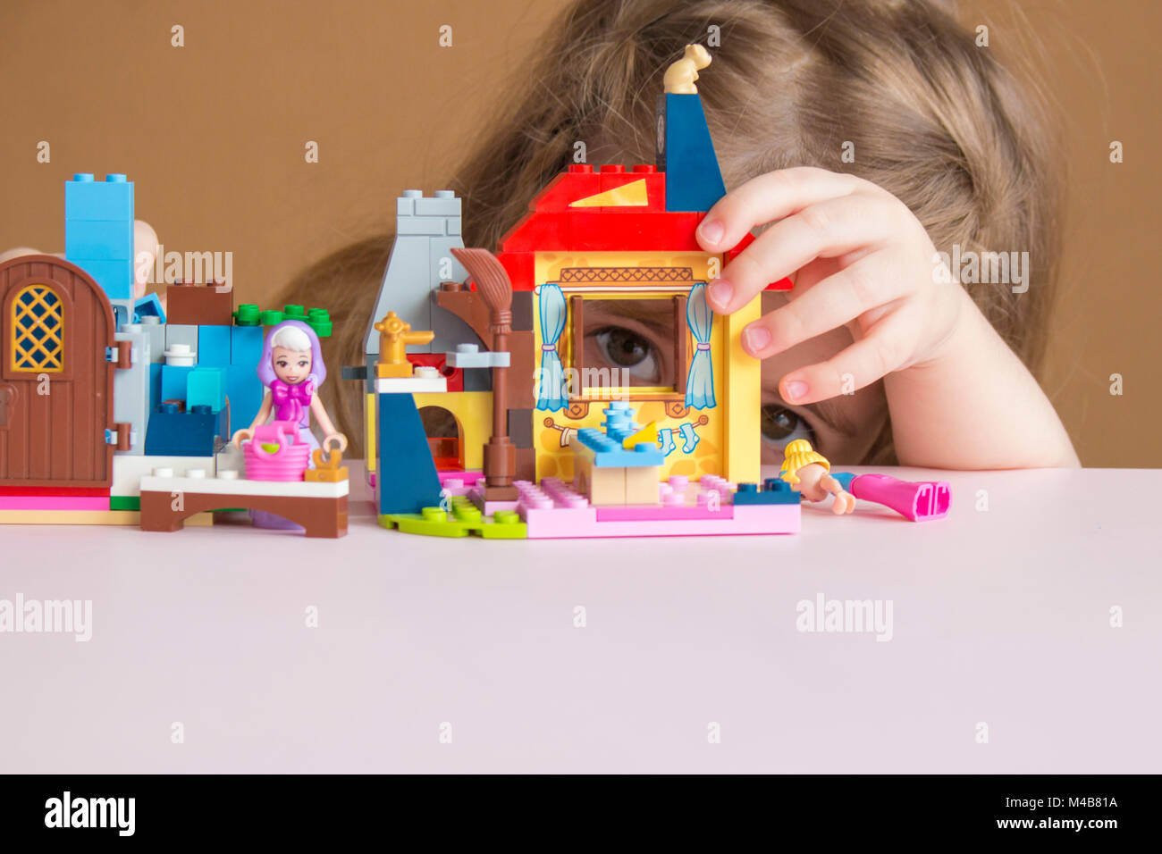 Cute funny Vorschüler kleine Mädchen spielen mit Bau toy Kleine Mädchen spielen kleines Spielzeug Bänder in Home
