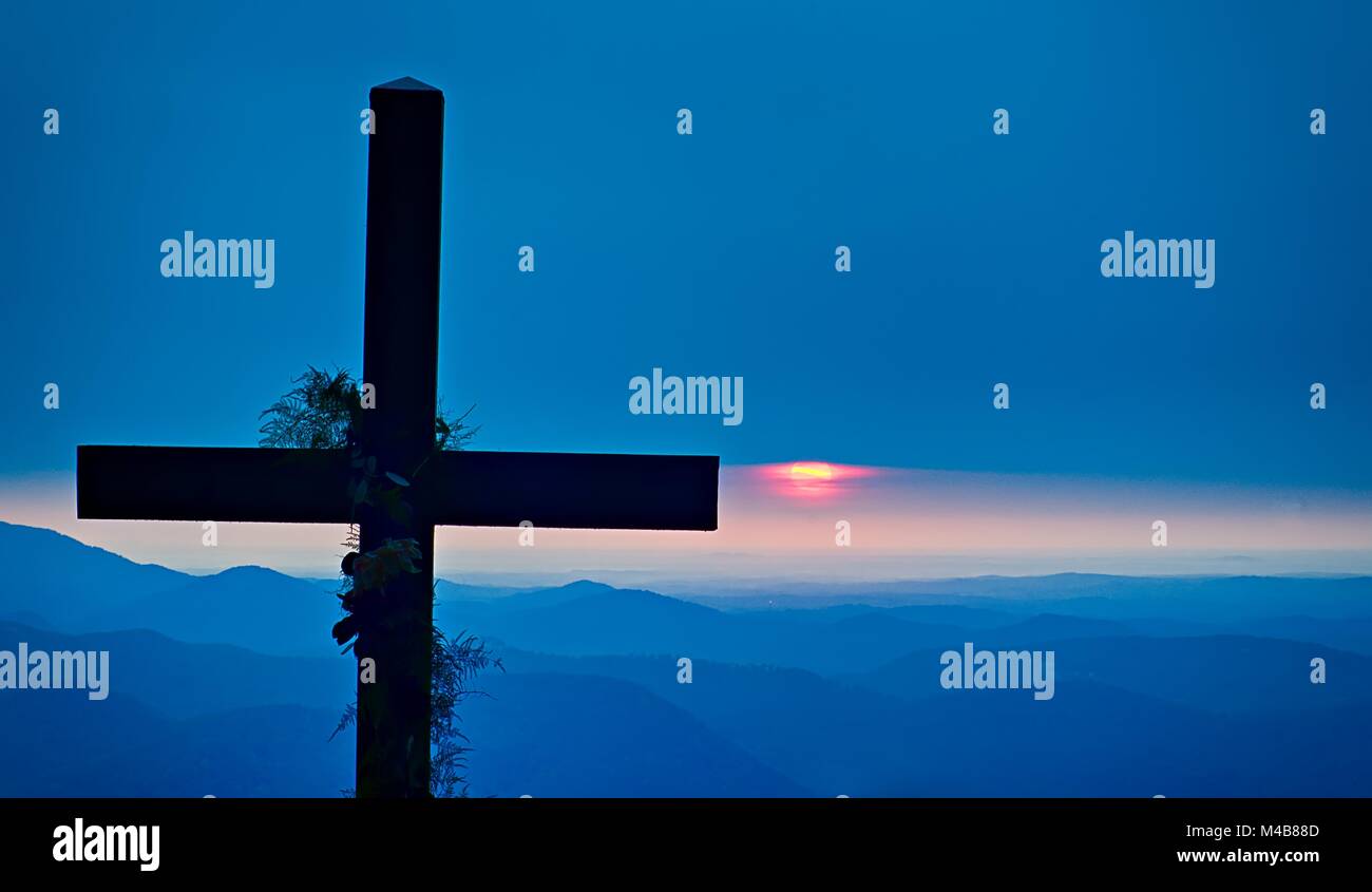 Der christliche Gottesdienst Kreuz mit Blick auf die Berge bei Sonnenaufgang Stockfoto