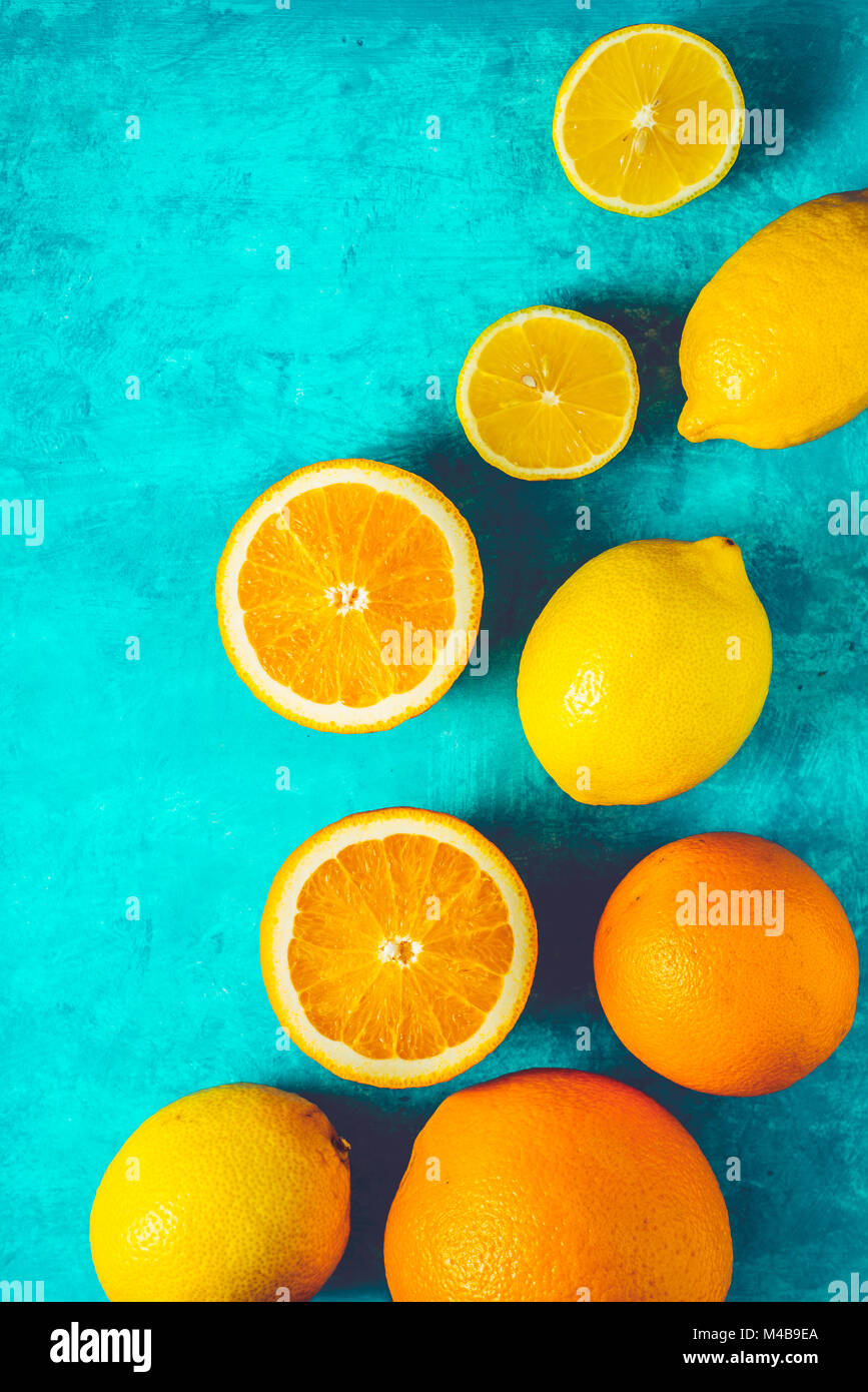Zitronen und Orangen auf dem blaugrünen Hintergrund vertikale Stockfoto