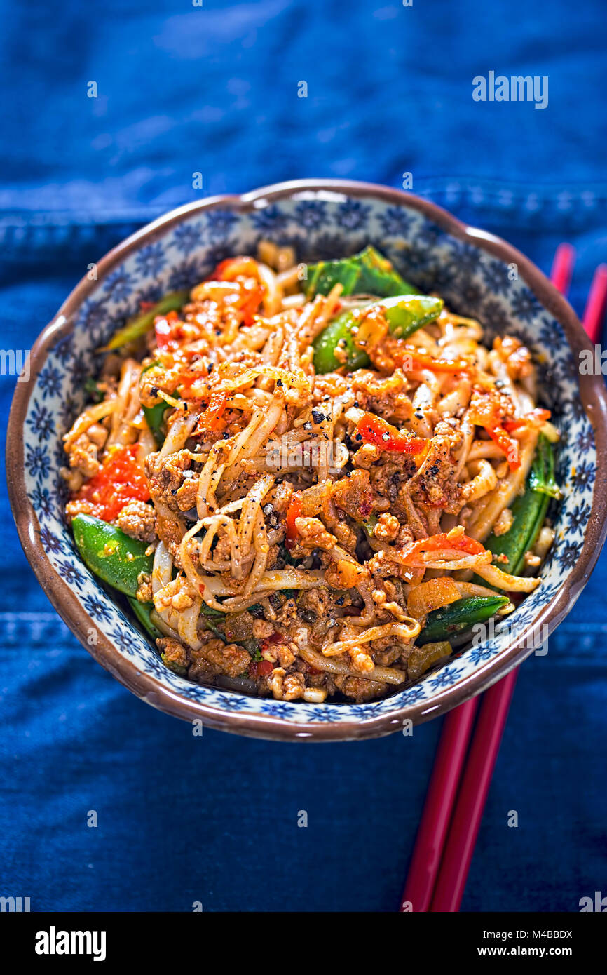 Sichuan spicy Schweinefleisch Nudeln mit Sojasprossen, Zuckerschoten und Eiche Choi Stockfoto