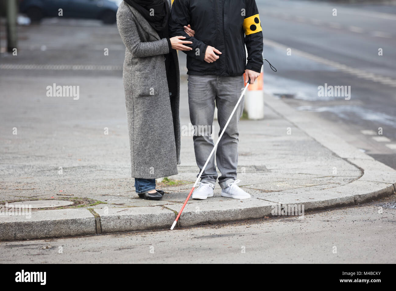 Nahaufnahme einer Frau, die mit einem blinden Mann auf der Straße Stockfoto