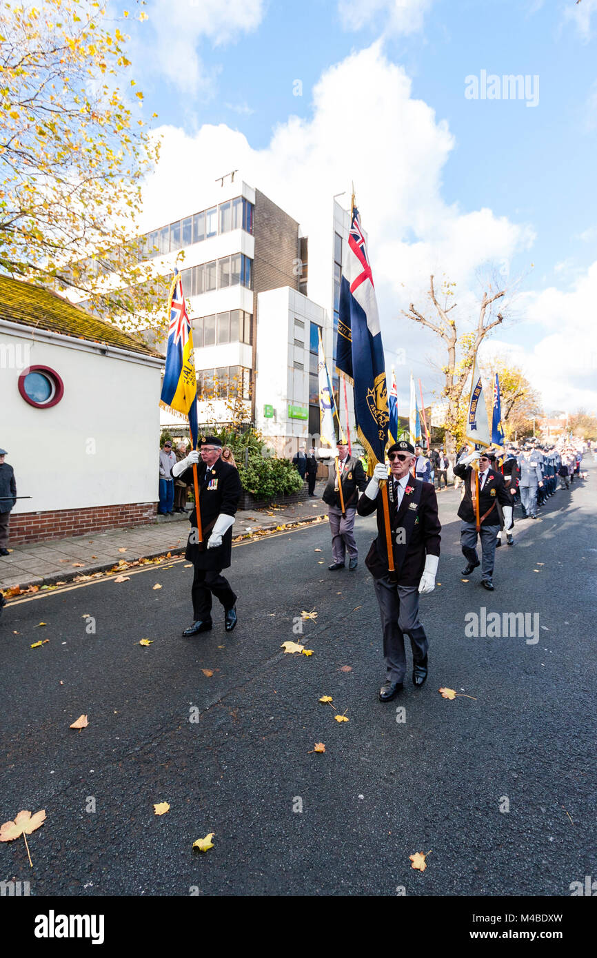 England, Ramsgate. Erinnerung Sonntag. Blick entlang Parade, ältere Männer halten Fahnen marschieren in der Mitte der Straße, verschiedene andere hinter sich. Stockfoto