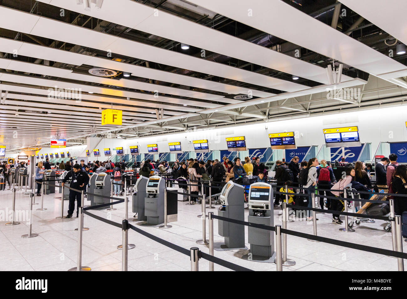 England, Heathrow Terminal 4. Leute anstellen an der Internationale Abflüge Schreibtische in der Kontrolle der mit Gepäck. Interieur. Nacht. Stockfoto