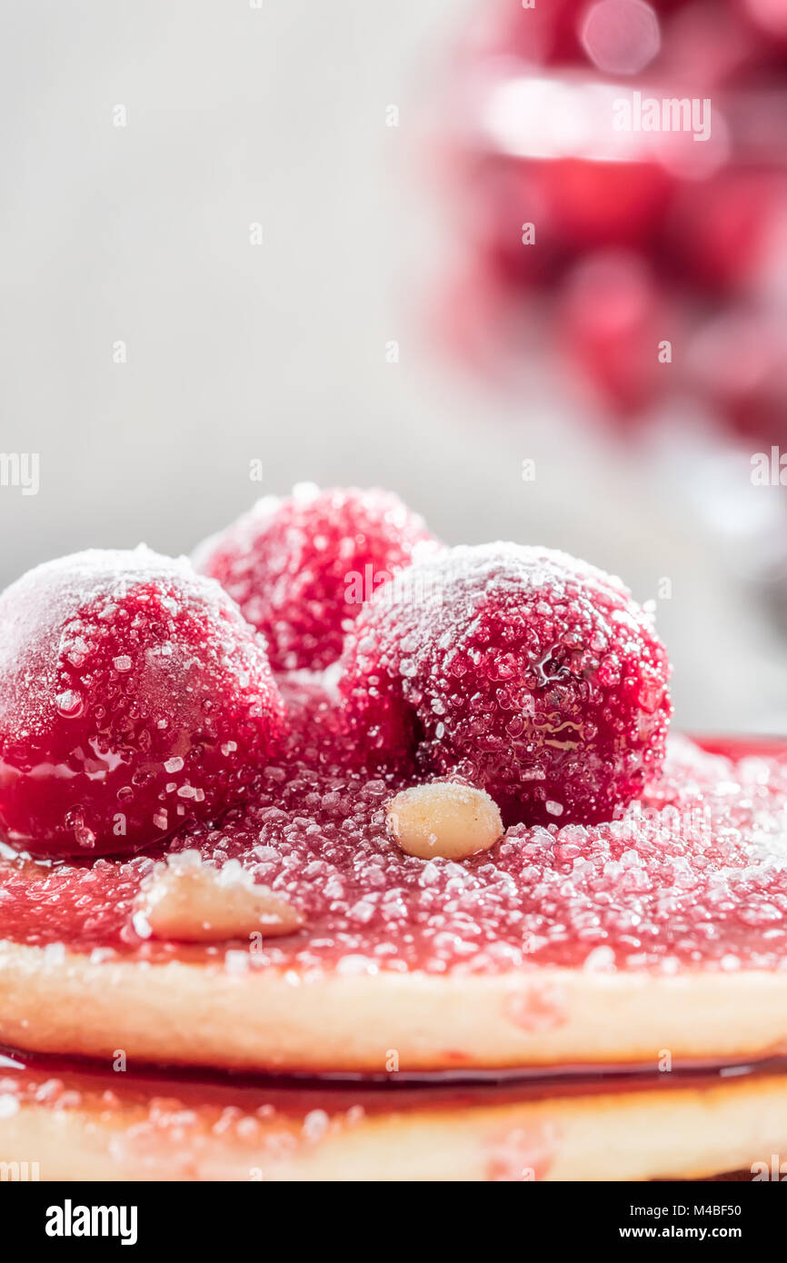 Pfannkuchen hausgemachte Kuchen mit Beeren gefroren Kirsche mit Puderzucker bestreut und Pinienkernen auf weißen Teller dekoriert Stapel Stockfoto