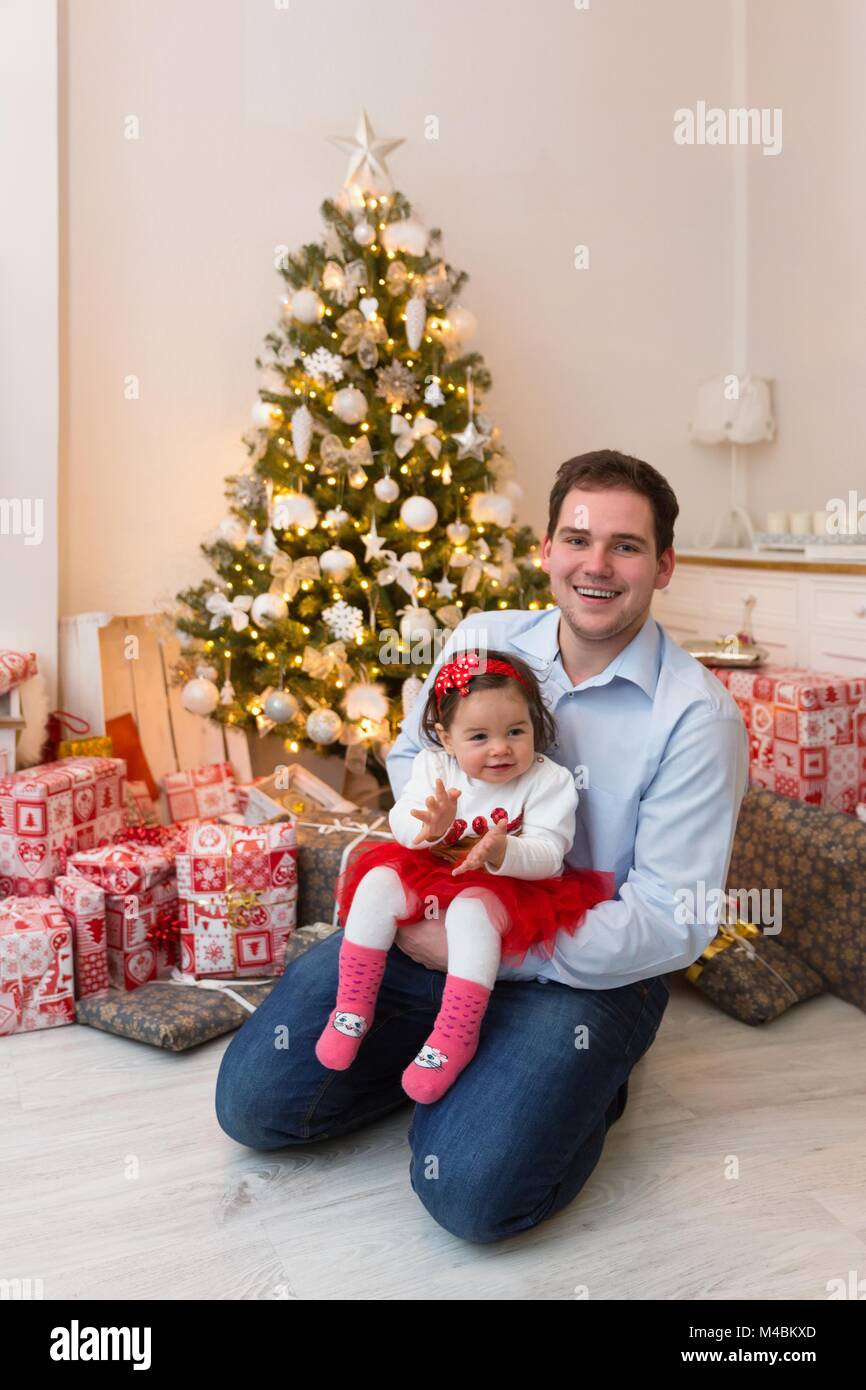 Junge, glückliche Familie vor dem Weihnachtsbaum Stockfoto