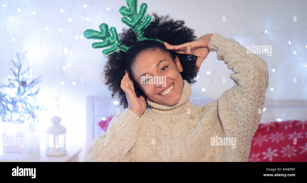 Verspielte junge Frau trägt Grün rentier Geweih Stockfoto