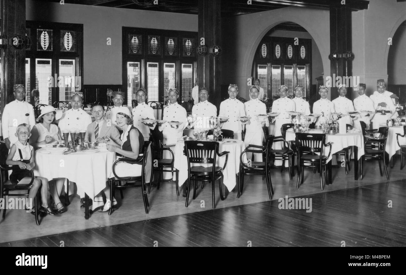 Die koloniale Geschichte, Kellner sorgen für eine Familie von vier im Restaurant, 1920er Jahre, dem genauen Ort unbekannt, Indonesien Stockfoto