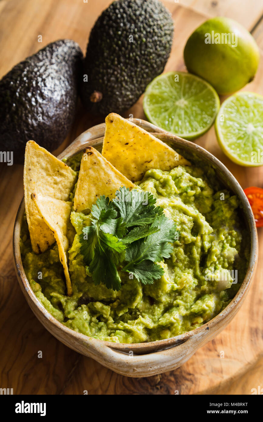 Tortilla Chips in Schale guacamole mit Avocado und Limetten