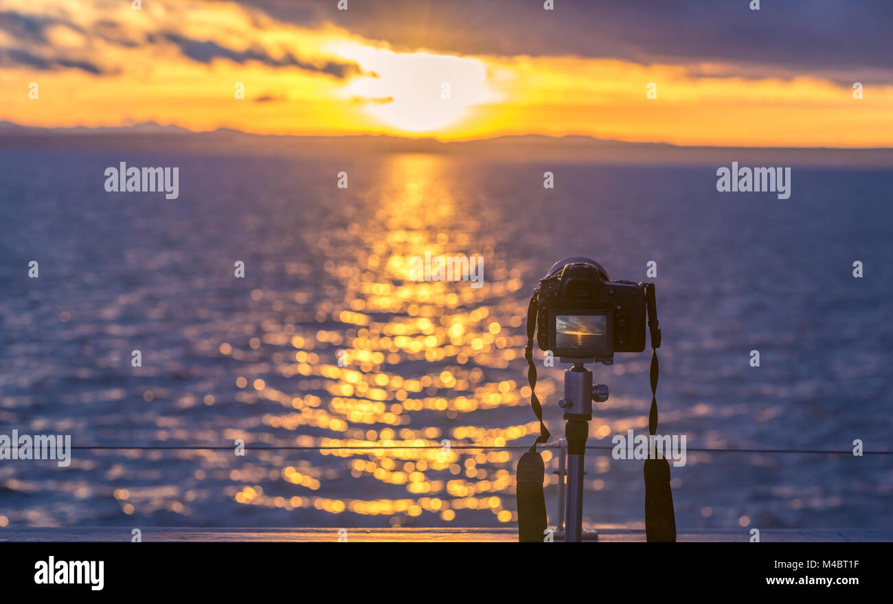 Sonnenuntergang über Wasser und einer DSLR-Kamera Stockfoto