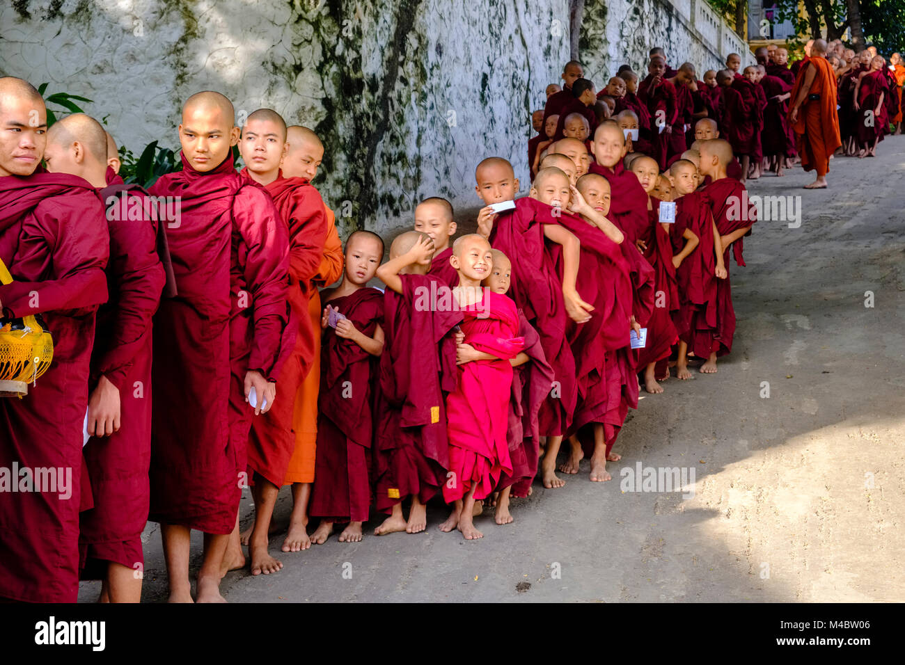 Buddhistische Mönche in Warteschlange stehen in einer langen Reihe Spenden in ein Kloster zu erhalten Stockfoto