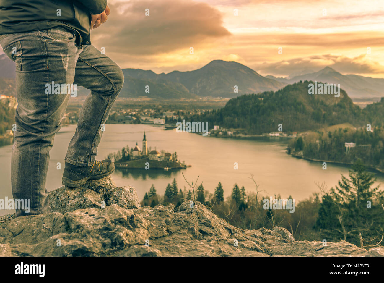 Mann kletterte auf den Felsen bei Sonnenaufgang Stockfoto