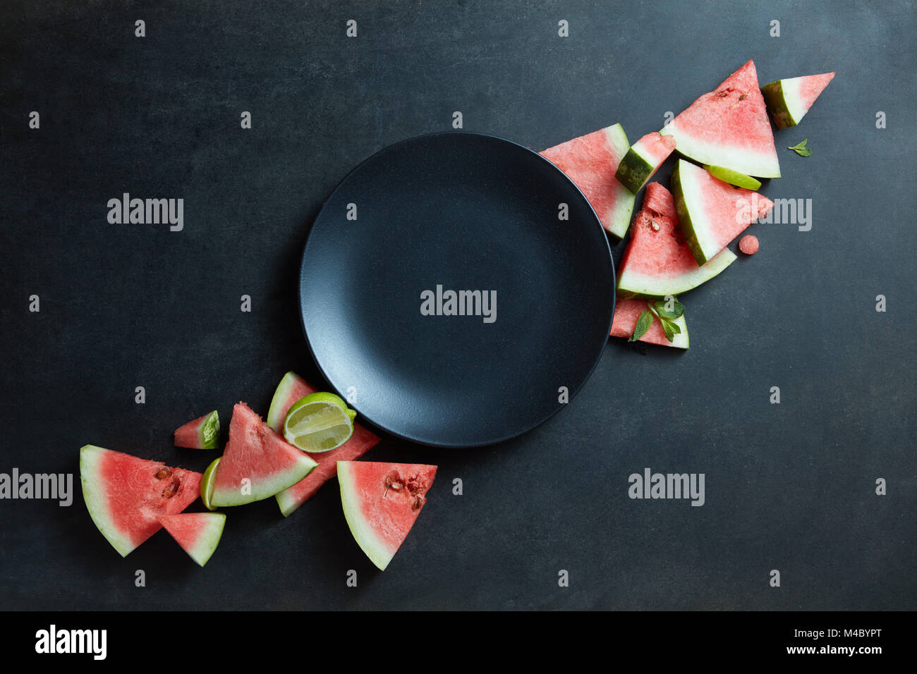 Scheiben der Wassermelone in einem Kreis auf schwarzem Teller platziert Stockfoto
