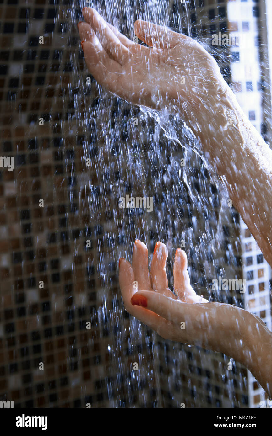 Die Hände der Frau in der Dusche Stockfoto