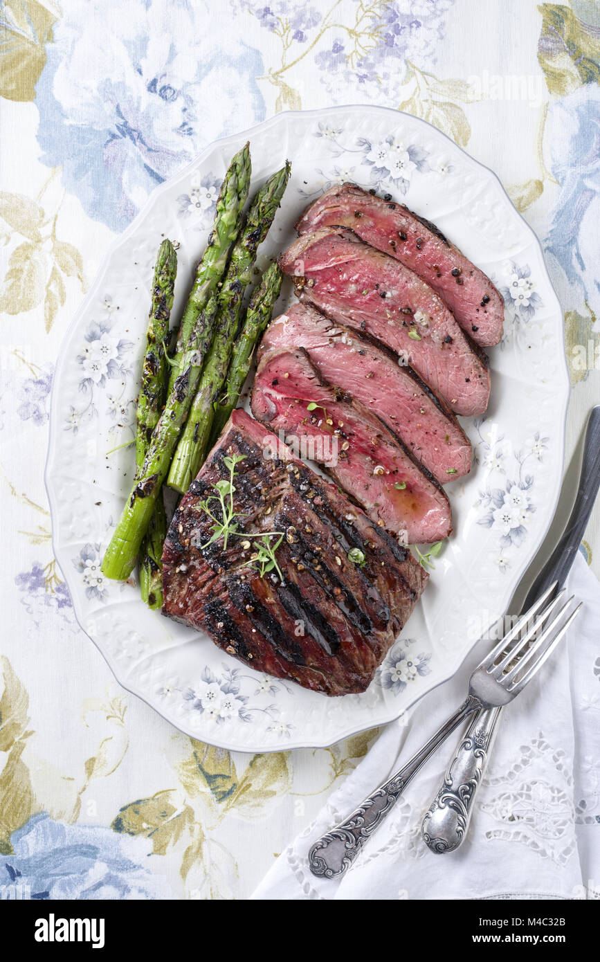 Grill Point Steak mit grünem Spargel auf dem Teller Stockfoto