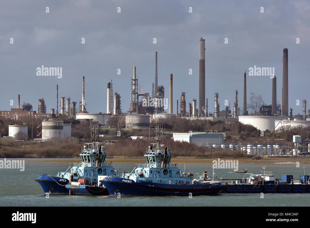Ostenjo rederi Schlepper und Boote neben der Marine Terminal an der Esso Öl oder Kraftstoff und gas Raffinerie in Fawley auf Wasser oder Southampton Docks in Hampshire. Stockfoto