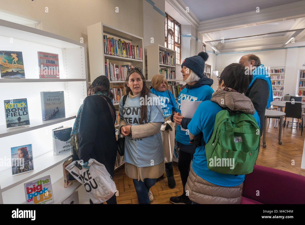 London, Großbritannien. 15. Februar 2018. Bibliothek Mitkämpfer schauen Sie sich um in der DENKMALGESCHÜTZTEN Carnegie Library als Lambeth Rat wieder öffnen, das Gebäude als vorübergehende Maßnahme im Vorfeld der Kommunalwahlen. Eine beleuchtete Bücherregal steht vor der Tür zum Lesen und WIldlfie Garten, die in den Wiederaufbau zerstört wurde. Credit: Peter Marschall/Alamy leben Nachrichten Stockfoto