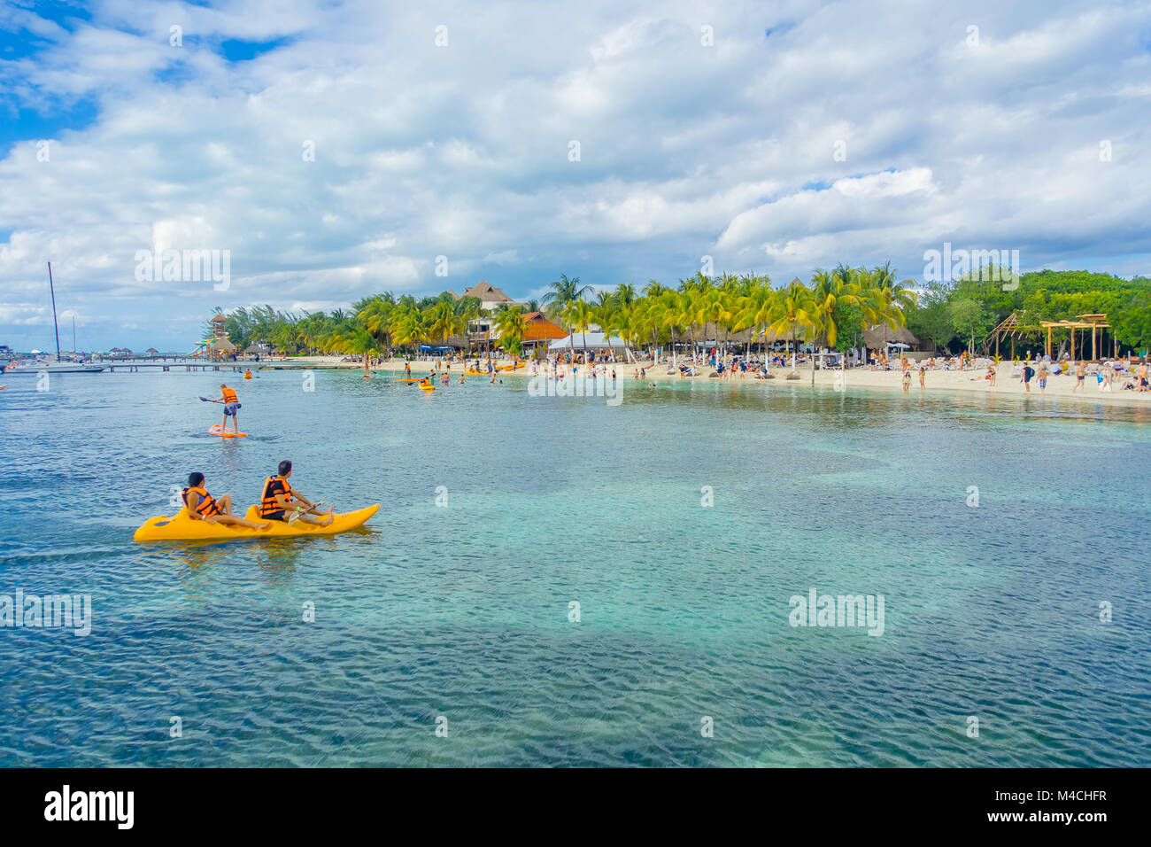 CANCUN, MEXIKO - Januar 10, 2018: Nicht identifizierte Personen Paddeln in ihre Kayack in einem wunderschönen karibischen Strand Isla Mujeres mit sauberen und transparenten Wasser in Mexiko, Sonne und Palmen. Tourismus Konzept Stockfoto