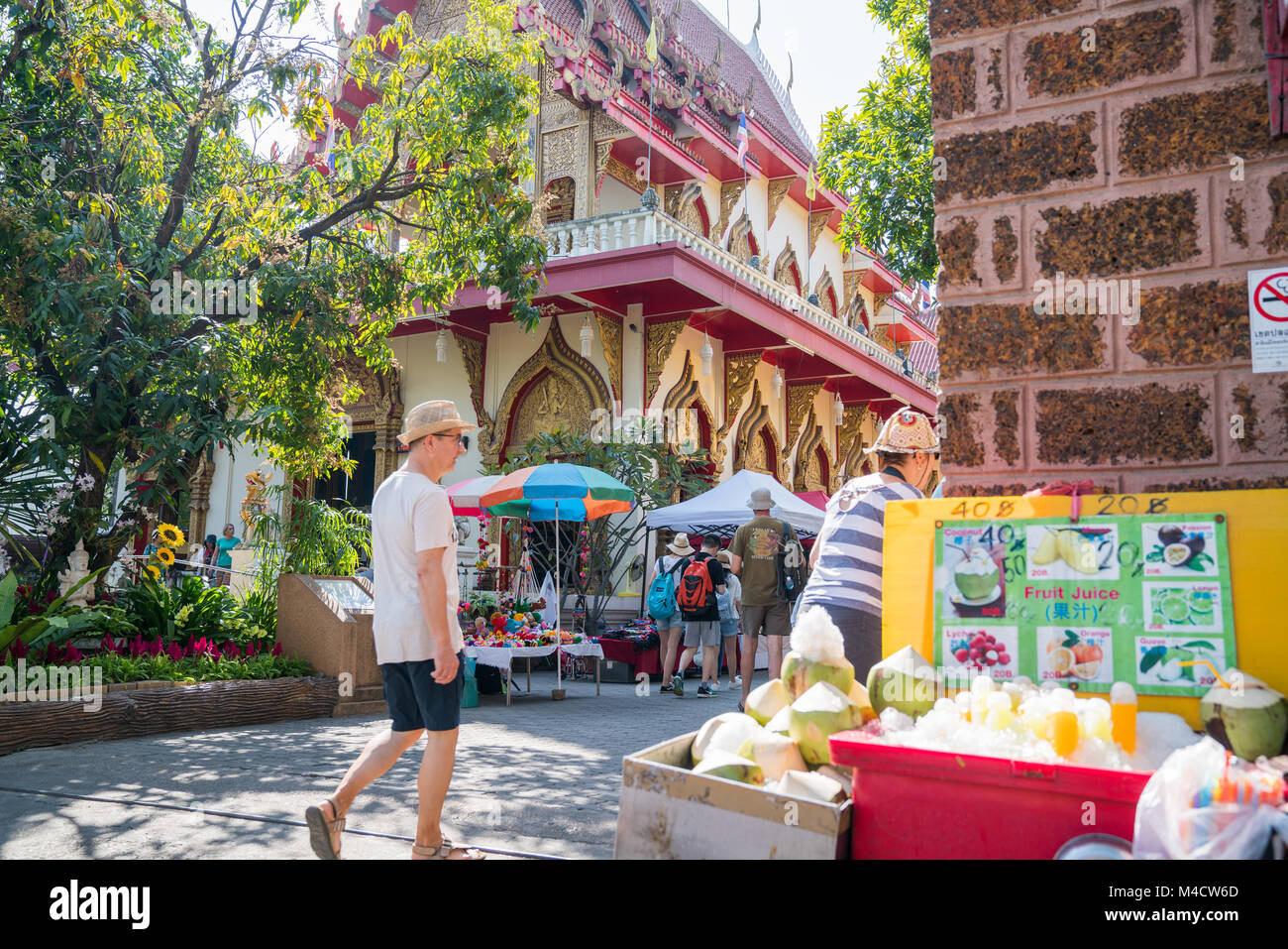 CHIANG MAI, THAILAND - 28. Januar 2018; städtische Szene schattigen Straße mit Passanten coconut Stall und Buddhistischen Tempel in der Regel asiatischen Stadt stree Stockfoto