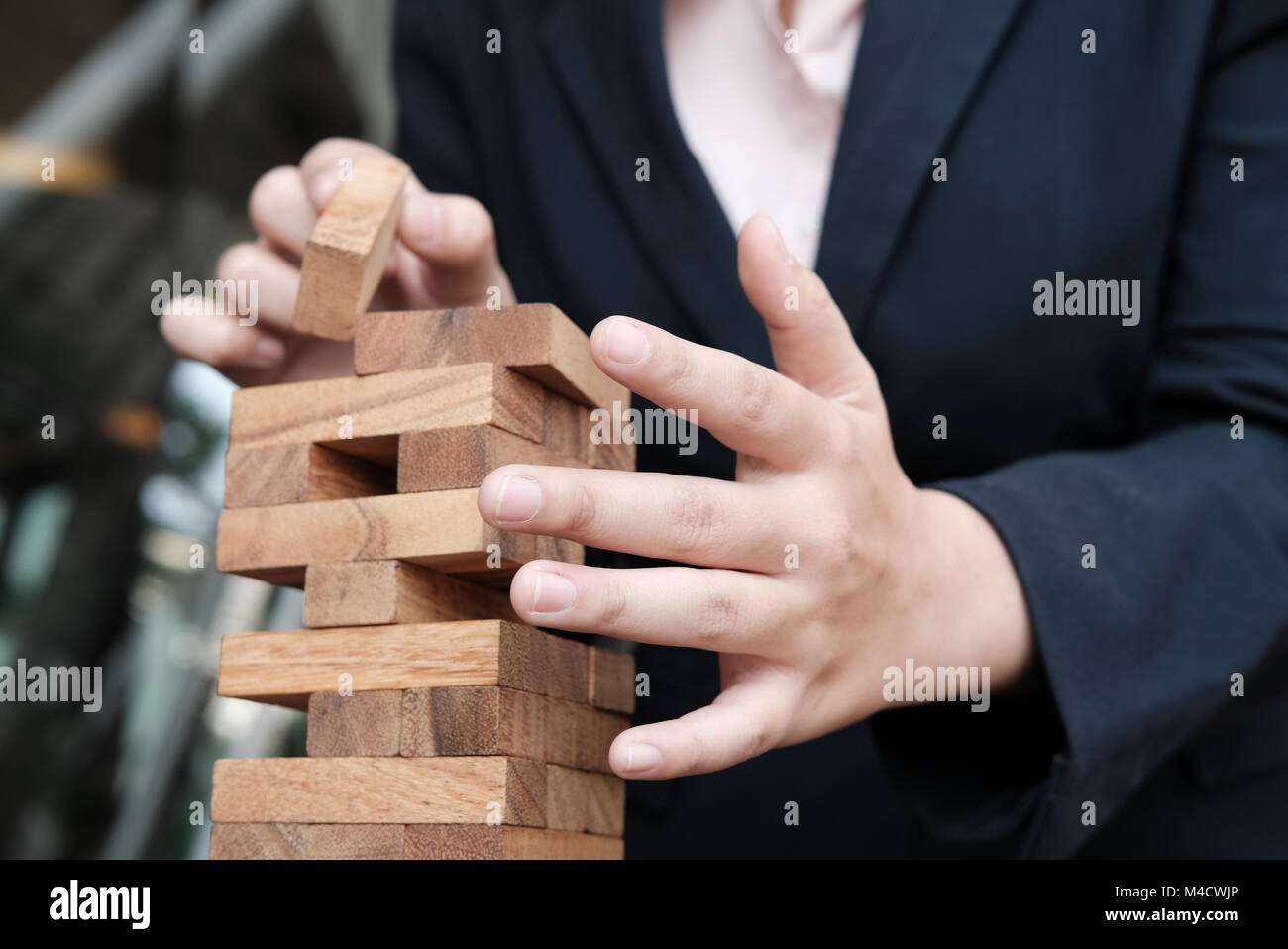 Geschäftsfrau hand Holzklotz auf Turm. Wachstum, Risiko und Strategie im Business. Stockfoto
