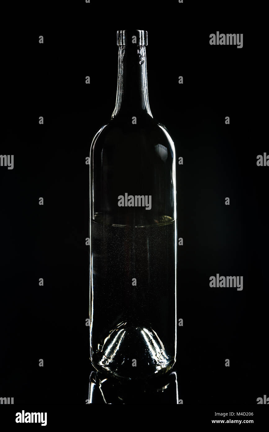 Eine transparente leere Glasflasche auf Schwarz Stockfoto
