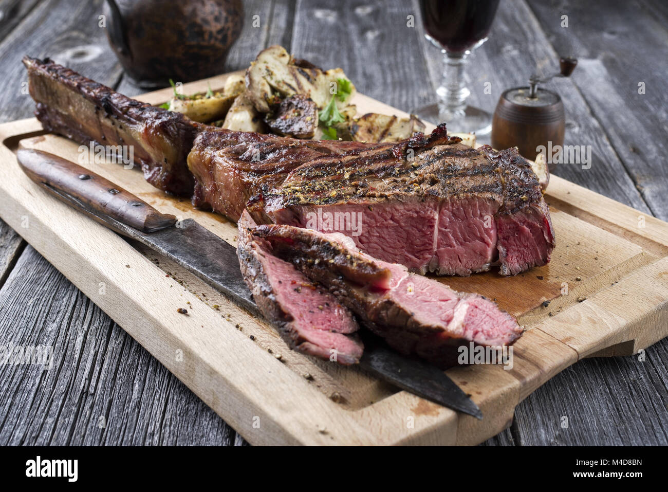 Grill Tomahawk Steak mit Pilzen auf Schneidebrett Stockfoto