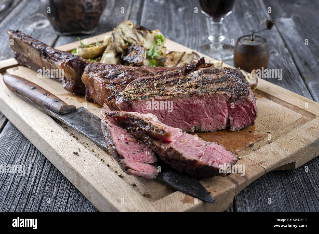 Grill Tomahawk Steak mit Pilzen auf Schneidebrett Stockfoto