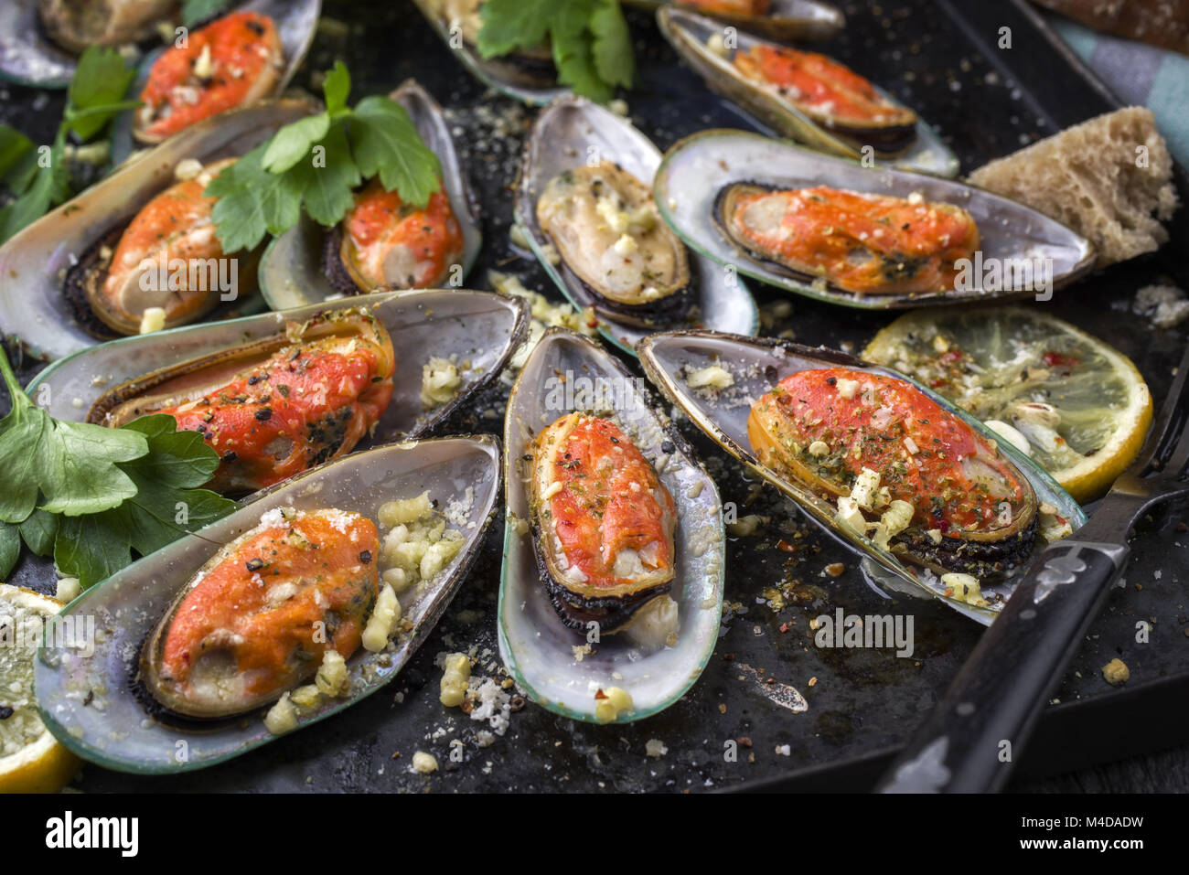 Gebackene grüne Shell Muscheln auf alten rustikalen Blatt Stockfoto