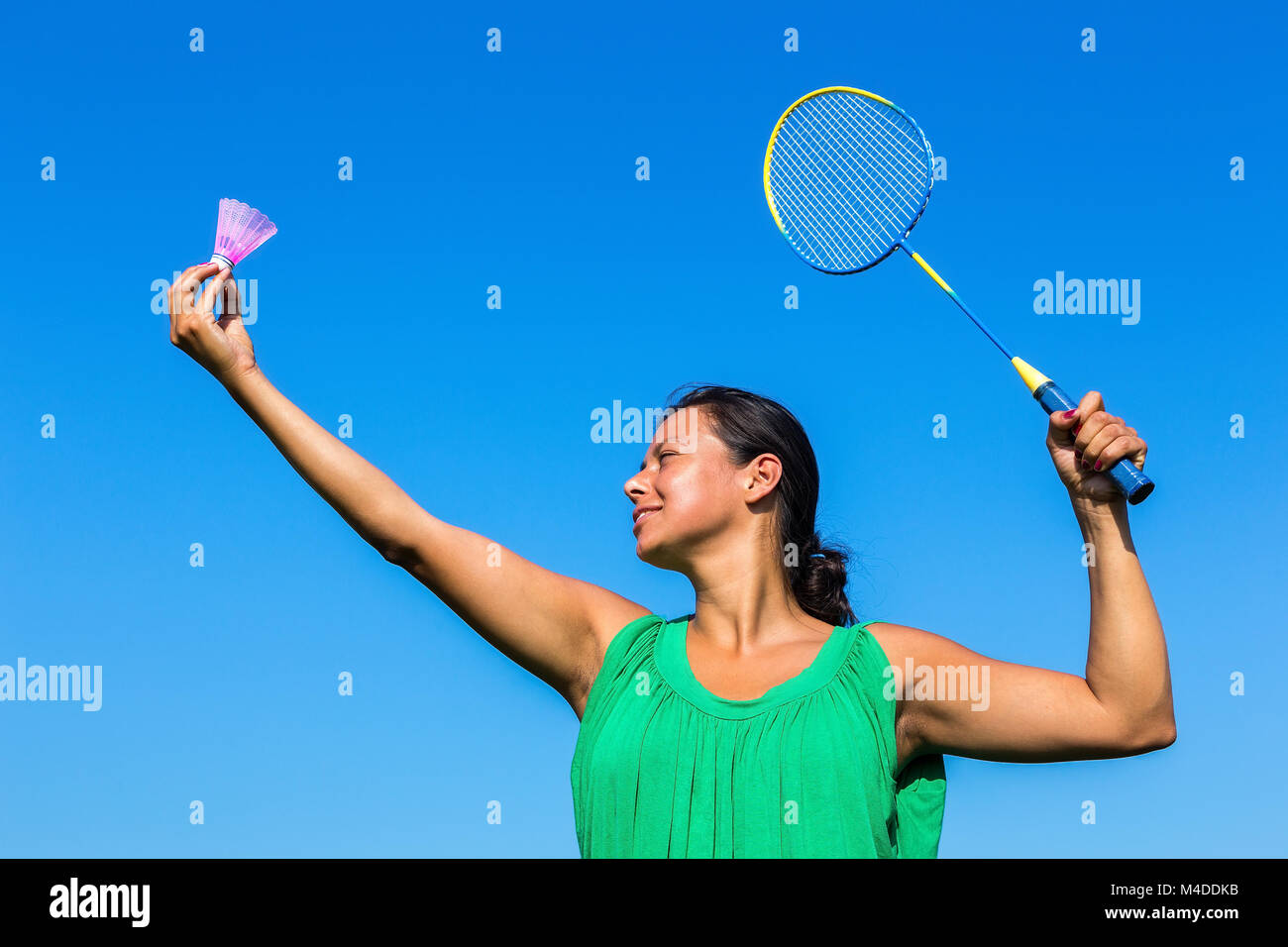 Kolumbianische Frau dienen mit Badminton Racket und Shuttle Stockfoto