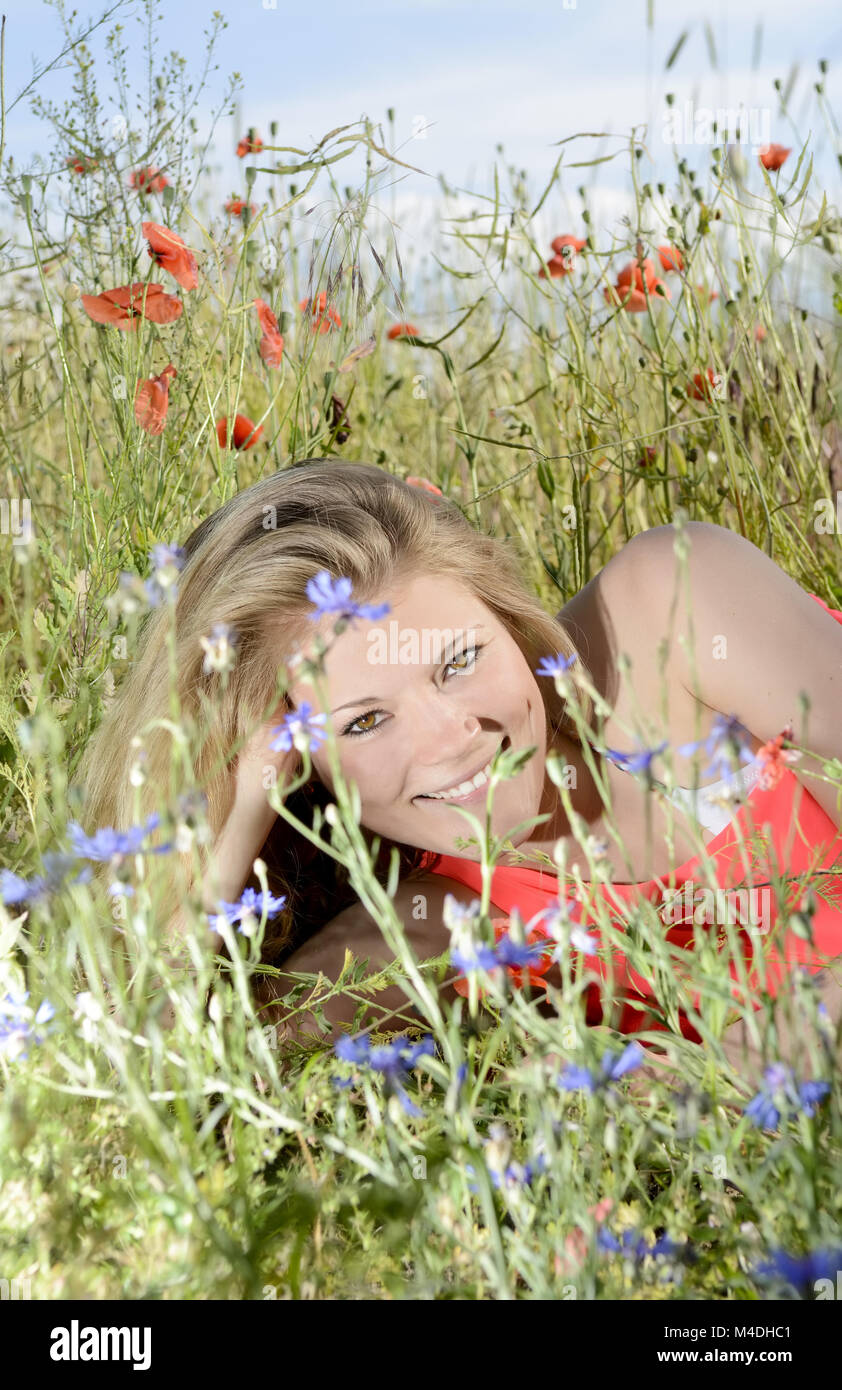 Liegende Frau auf der Blumenwiese Stockfoto